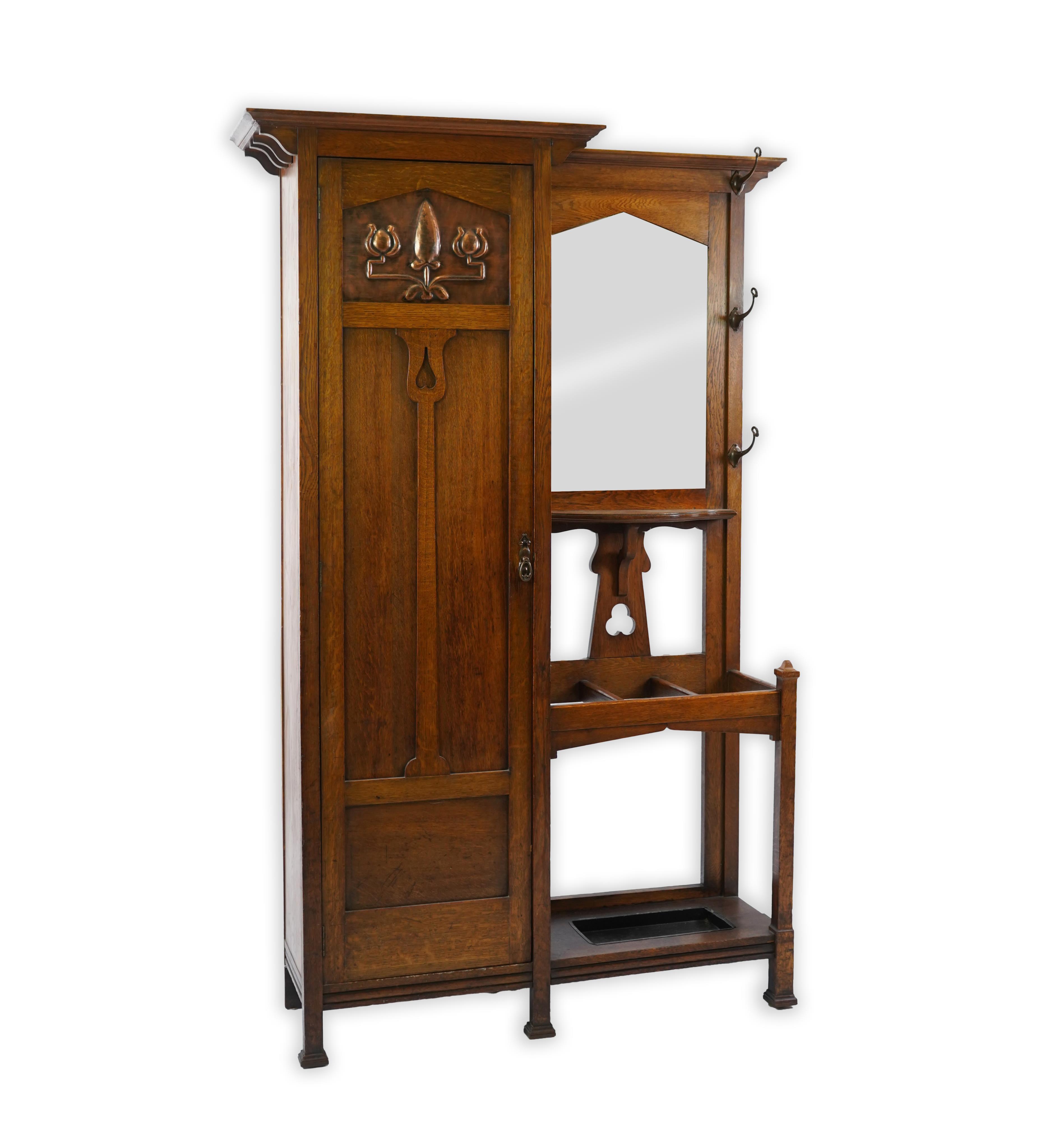 Manner of Liberty & Co: An Arts and Crafts embossed copper mounted oak hall cupboard